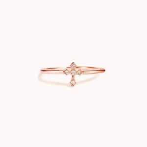 Delicate diamond cross ring in rose gold with a thin band.