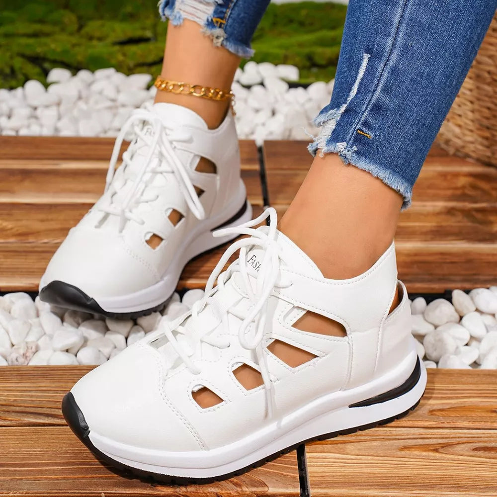 Chic white round toe lace-up sneakers with cut-out details and a black sole.