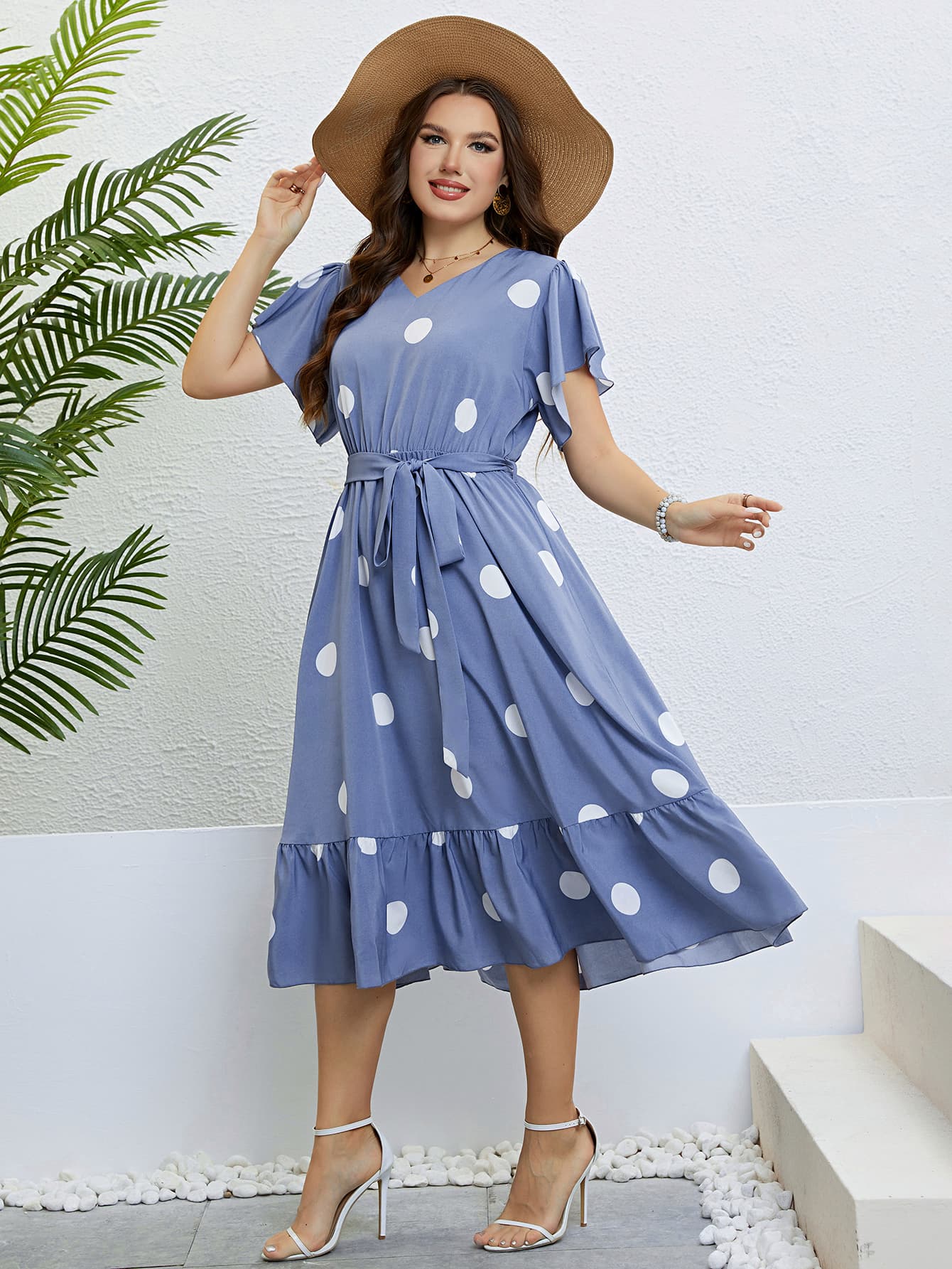 Cerulean polka dot midi dress with flutter sleeves, v-neck, tie waist, and ruffled hem.