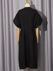 Black midi dress with puff sleeves and a-line skirt, featuring rhinestone embellishments.