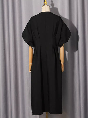 Black midi dress with puff sleeves and a-line skirt, featuring rhinestone embellishments.