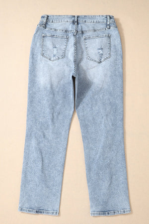 Distressed wash light blue denim slim leg jeans with ripped back pockets.