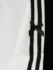 White zip-up hoodie with black stripes and a black bow detail.