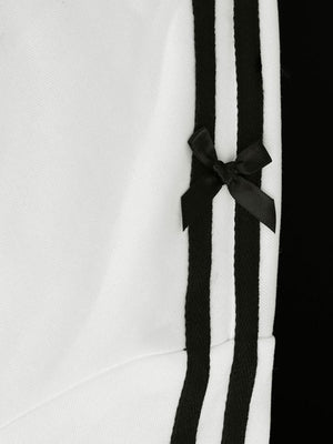 White zip-up hoodie with black stripes and a black bow detail.