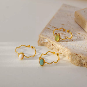 Wavy gold-plated ring with oval natural stone, delicate adjustable accessory for women.