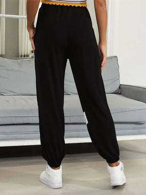 Black joggers with drawstring waist and diagonal white panel detail.