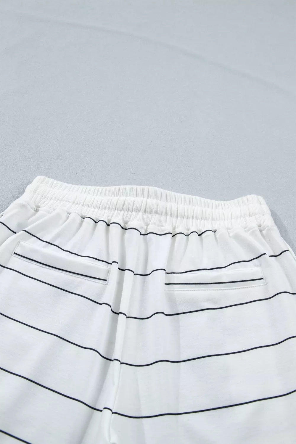 White striped bikini bottoms with drawstring waist and back pockets.