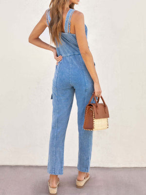 Acid wash denim cargo jumpsuit with drawstring waist and straight leg pants.