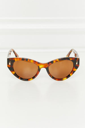 Cat-eye tortoise shell acetate sunglasses with brown lenses and gold accents.