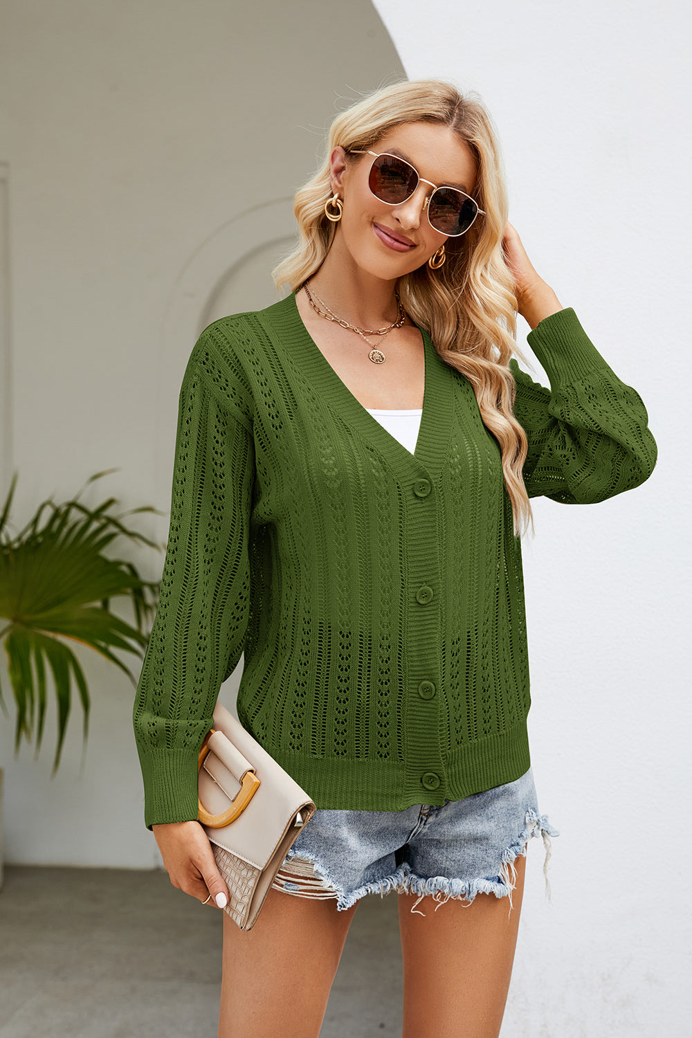 Green openwork knit button-down cardigan with V-neck and long sleeves.