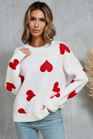 White acrylic knit jumper with red intarsia hearts, crew neck, long sleeves.