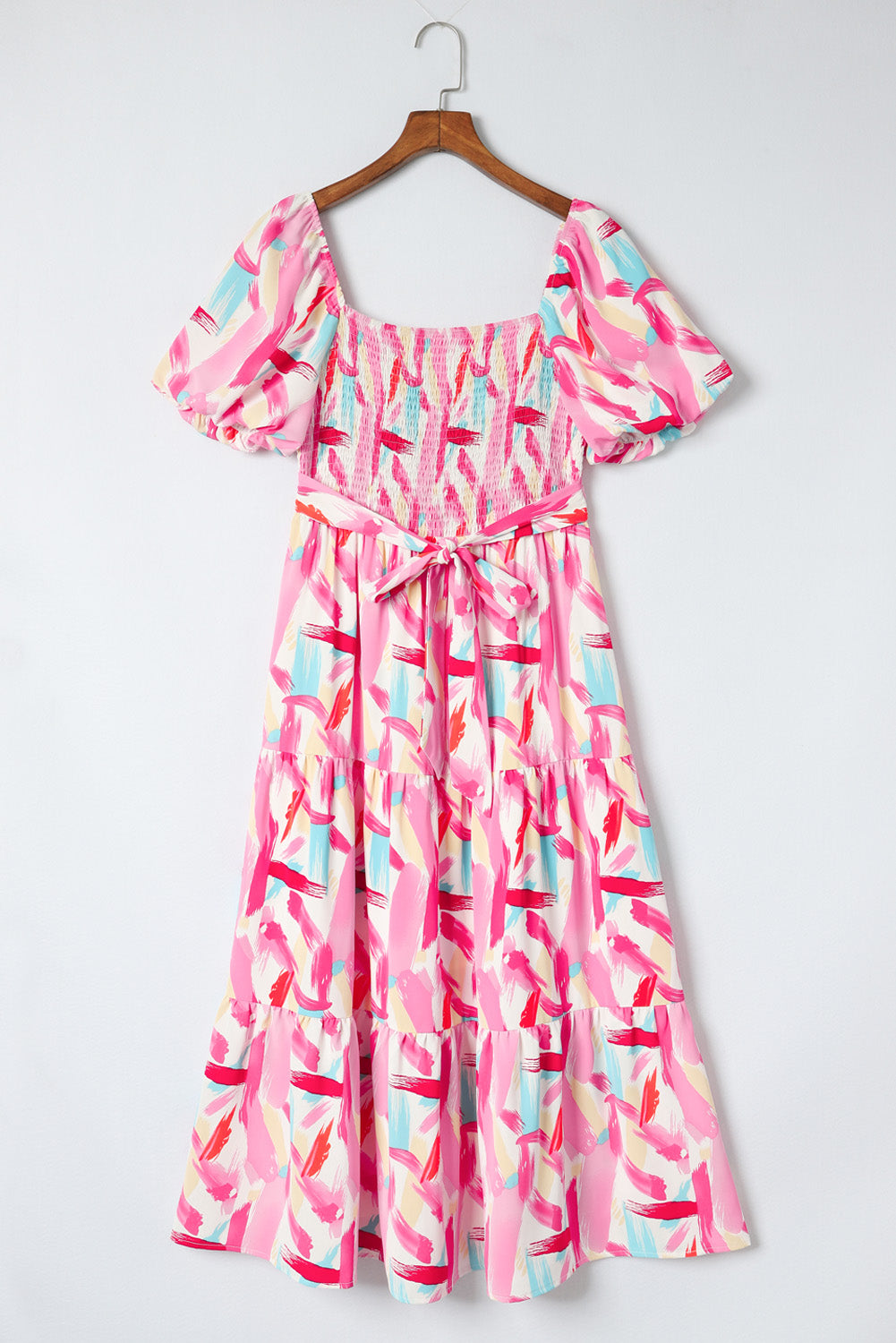 Blush pink midi dress with smocked bodice, balloon sleeves, tiered skirt, and brushstroke print.