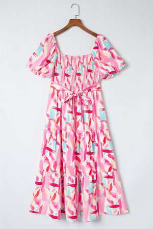 Blush pink midi dress with smocked bodice, balloon sleeves, tiered skirt, and brushstroke print.
