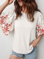 White ribbed top with floral print half sleeves and a crew neck.