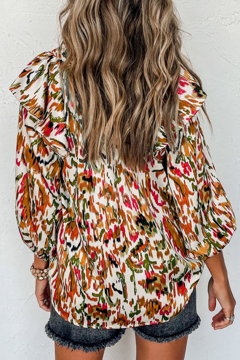 Ruffled Aura Sleeve Blouse in abstract print with ruffled shoulders and long sleeves.