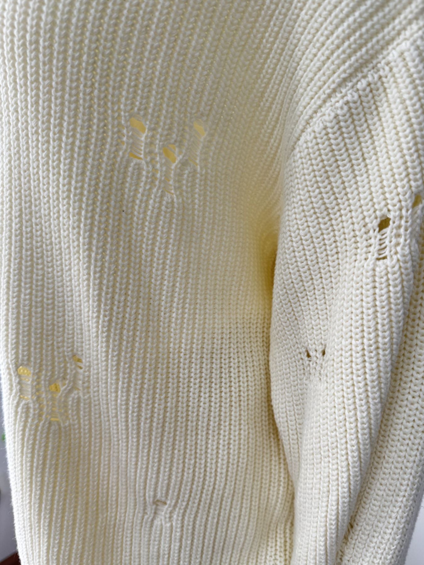 Off white distressed cotton sweater with deconstructed details and ribbed knit texture.
