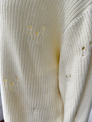 Off white distressed cotton sweater with deconstructed details and ribbed knit texture.