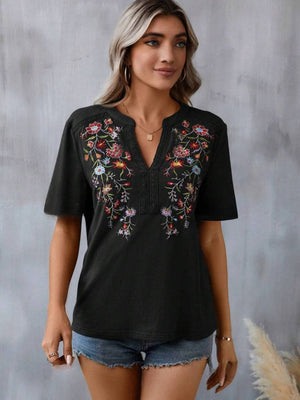 Black V-neck tee with colorful floral embroidery and crochet trim detail.