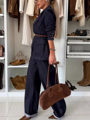 Dark blue denim double-breasted blazer and wide-leg pants, cinched with a brown belt.