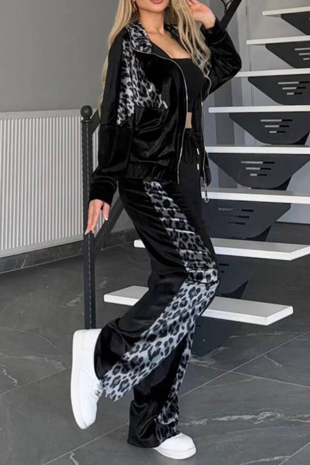 Black velvet tracksuit with leopard print panels on jacket and pants.