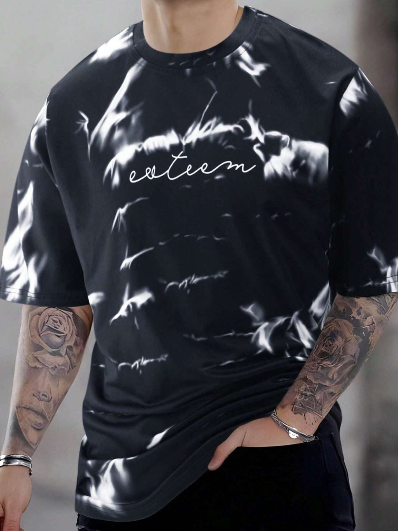 Men's black cotton oversized t-shirt with abstract tie-dye pattern and white text graphic.