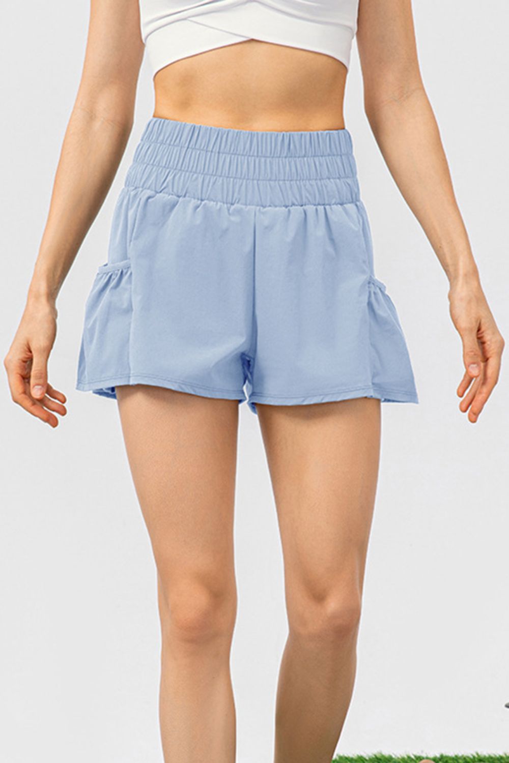 Light blue active shorts with gathered waistline and ruffled pockets.