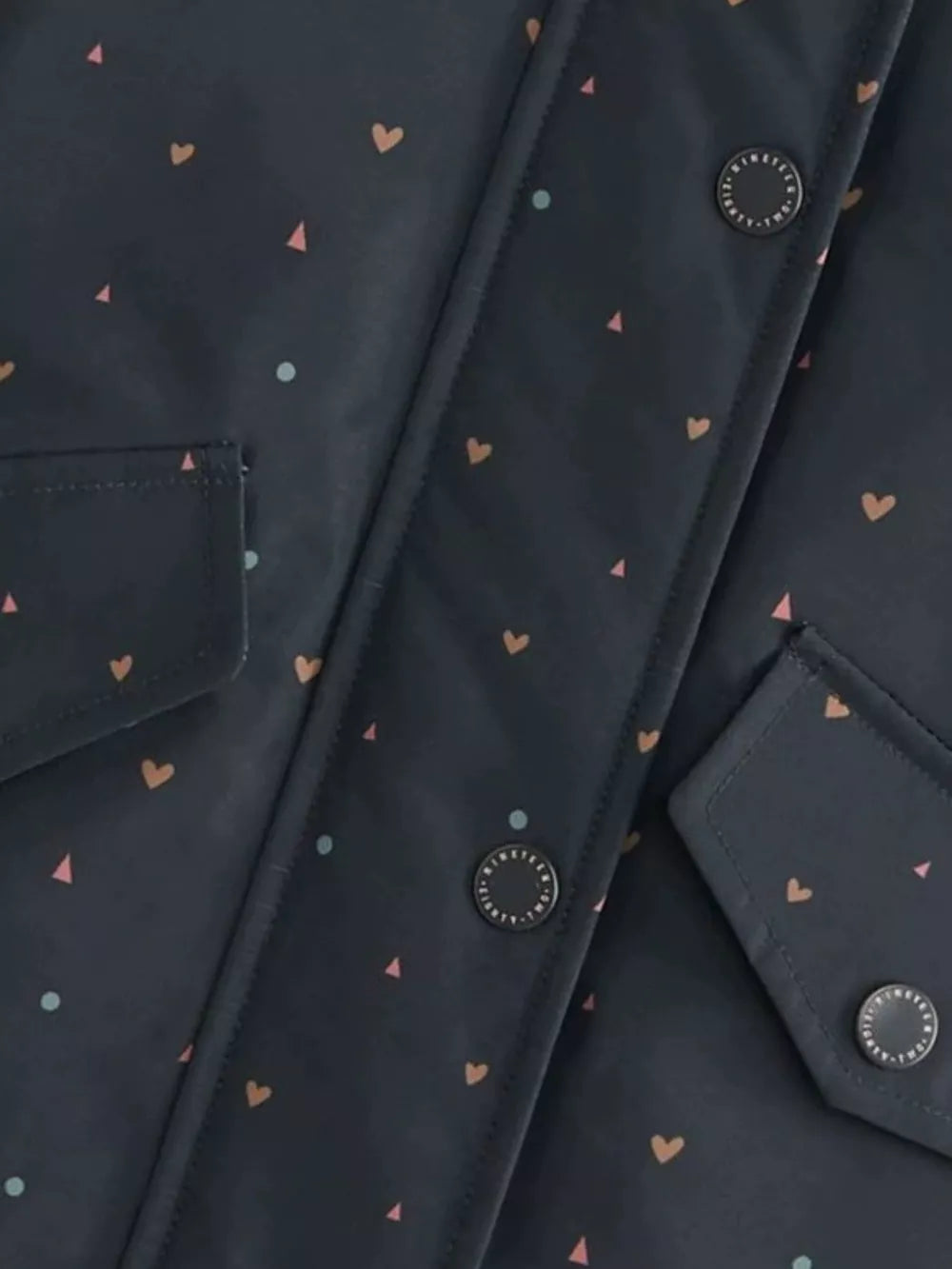 Toddler jacket with allover heart and triangle print, featuring button details and pockets.