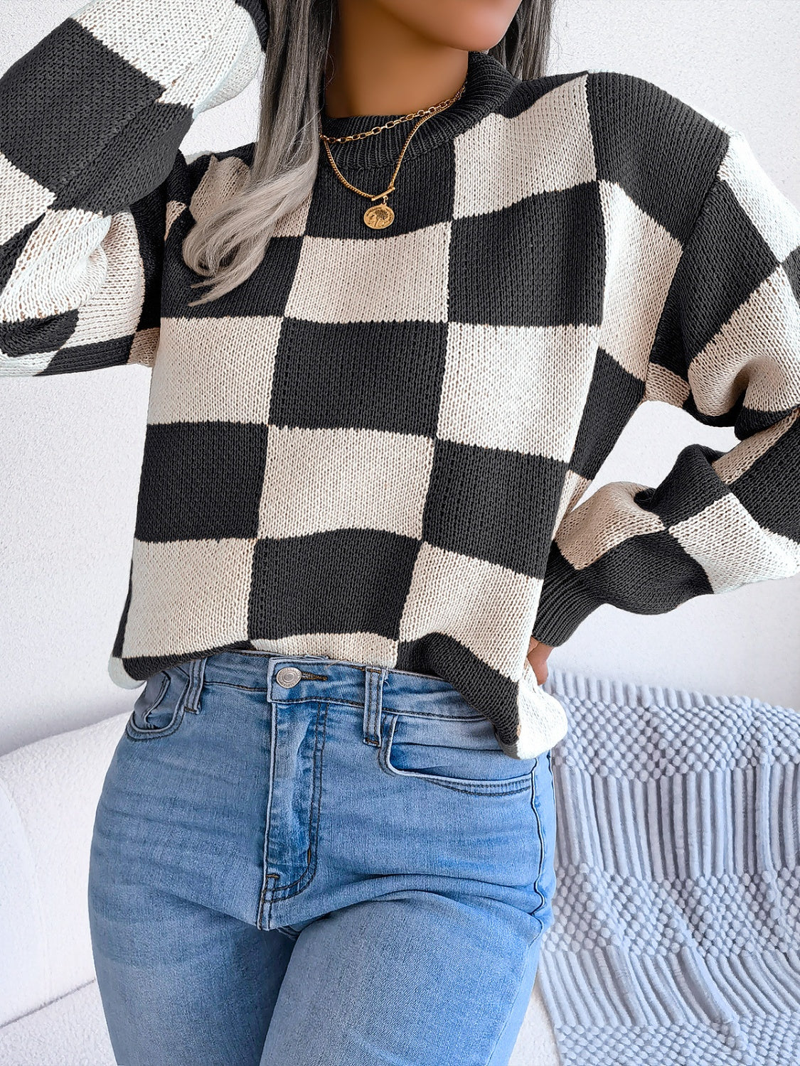 Checkerboard knit mock neck pullover sweater in black and white acrylic with long sleeves.