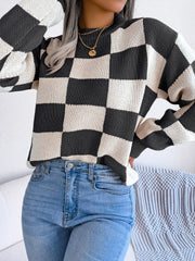 Checkerboard knit mock neck pullover sweater in black and white acrylic with long sleeves.