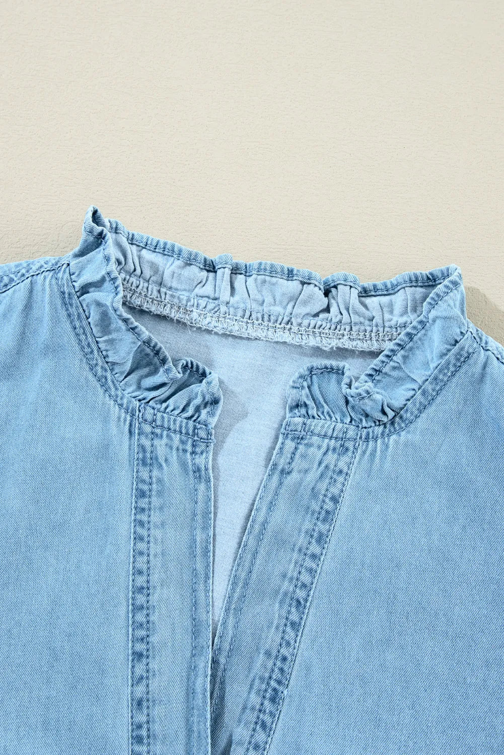 Light blue denim shirt dress with ruffled collar and button placket detail