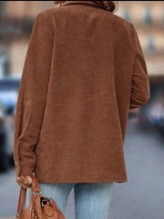 Brown corduroy shirt jacket with button details and long sleeves.