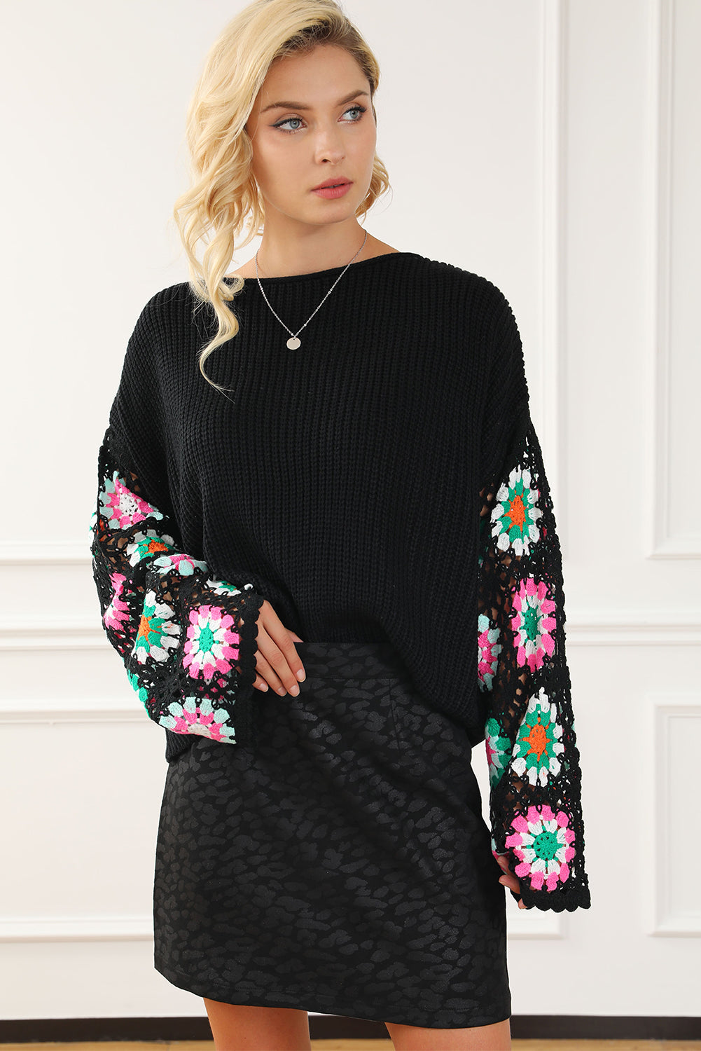 Black knit pullover sweater with colorful granny square crochet sleeves and boat neck.