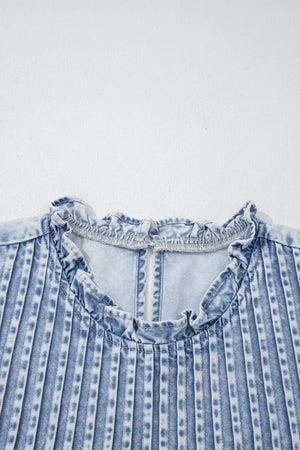 Denim blouse with ruffled neckline and vertical pleats.