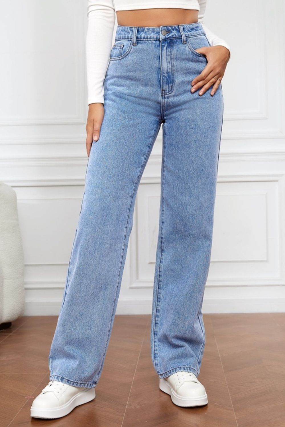 Light blue wide-leg denim jeans with a sculpted high rise, styled with a white top and sneakers.