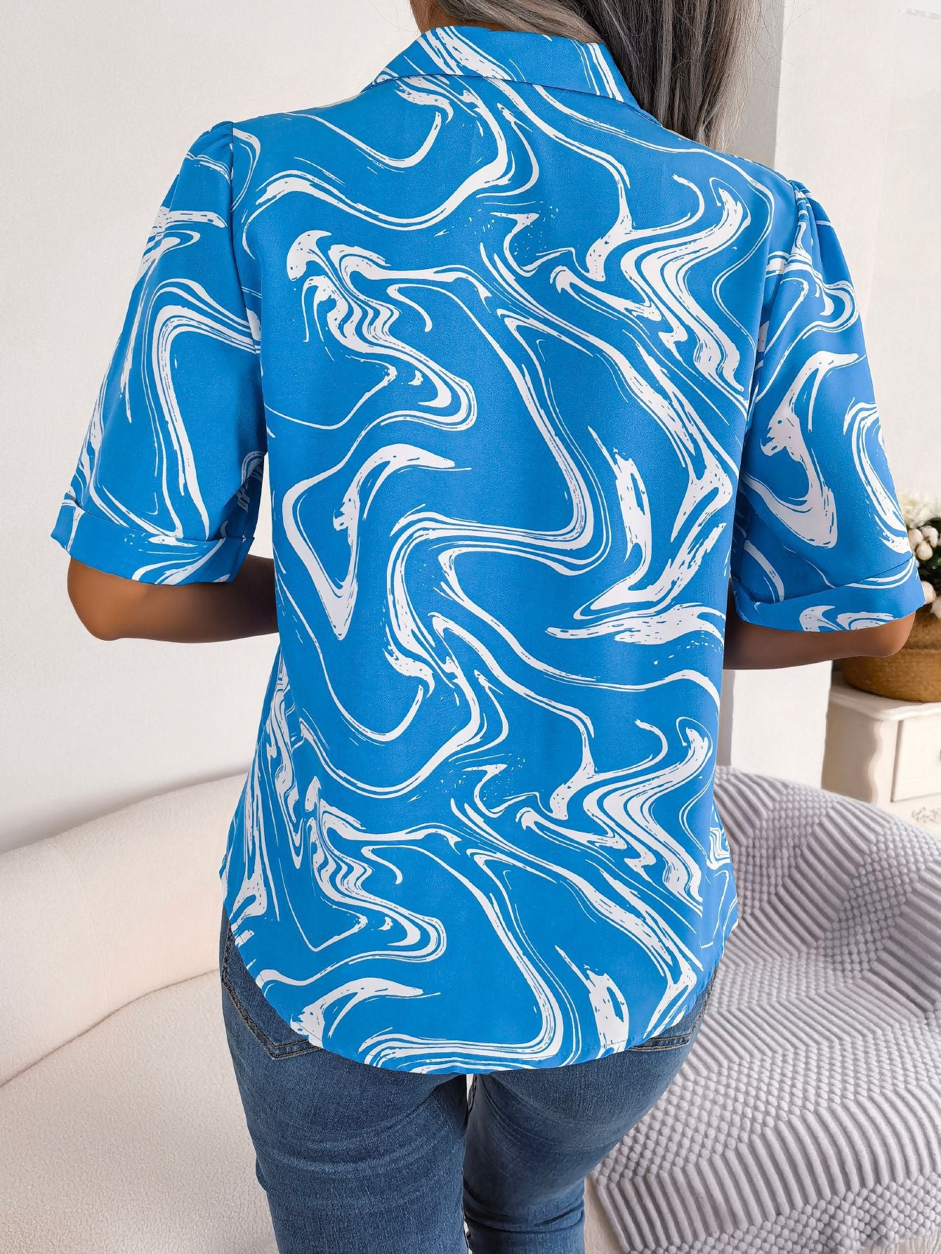 Sky blue swirl print camp collar blouse with short sleeves.