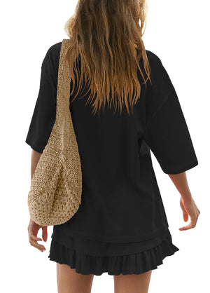 Black ruffled tee and skirt set with a woven crossbody bag.