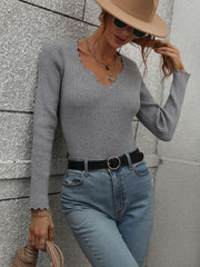 Gray ribbed knit top with scalloped V-neck and long sleeves.