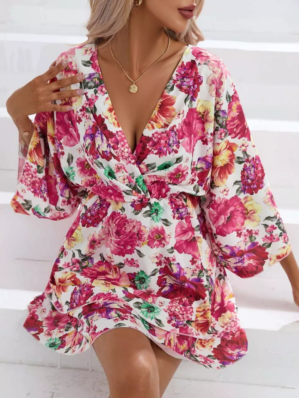 Floral ruffle hem mini dress with a deep V-neck and wide sleeves.