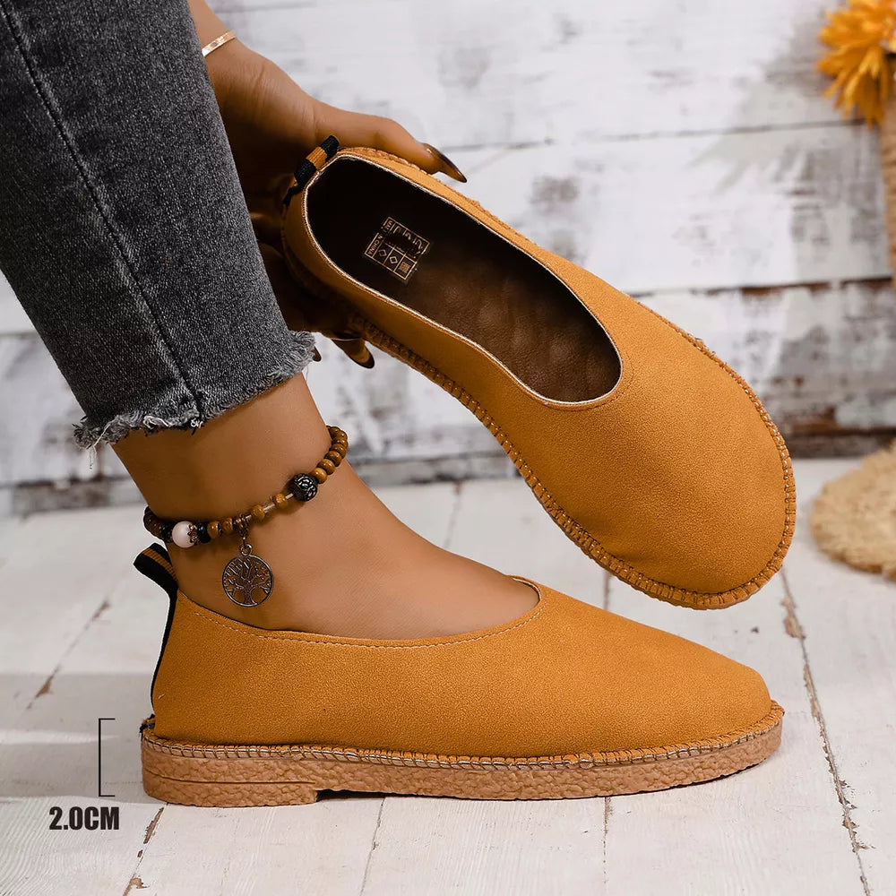 Yellow round toe comfort flats with stitched sole detail and ankle strap.
