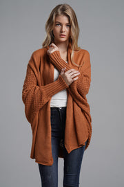Terracotta acrylic cocoon knit sleeve cardigan with textured sleeves and ribbed cuffs.
