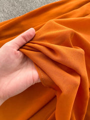 Orange red maternity dress fabric detail, showing flowy material and texture.