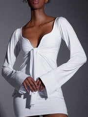 White tie-front long sleeve blouse with a deep V-neckline and flared cuffs.
