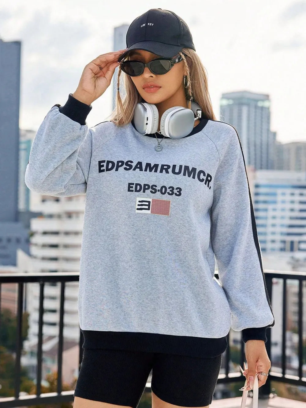 Light gray cotton sweatshirt with graphic print and varsity stripes on sleeves.