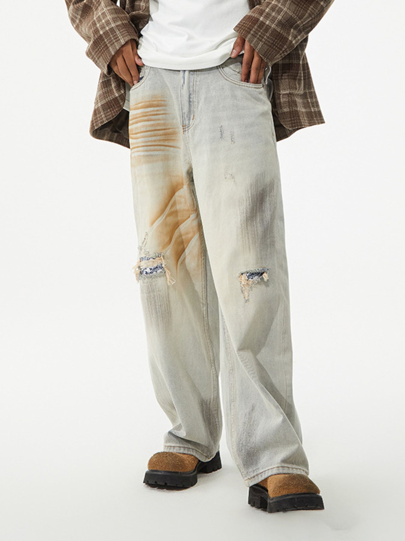 Light wash distressed wide-leg jeans with unique graphic patches and ripped details.
