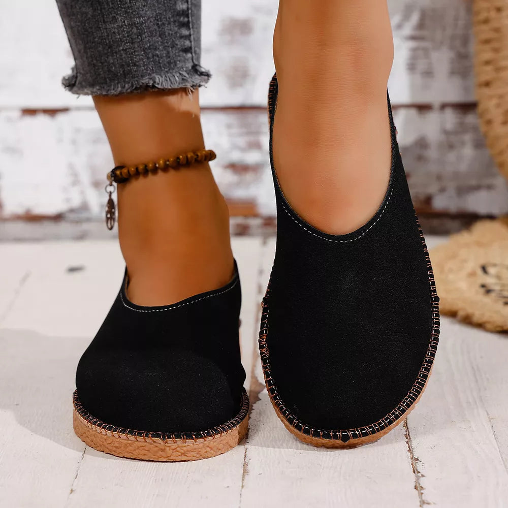 Black espadrille-inspired round toe slip-on flats with decorative stitching and a jute-like sole.