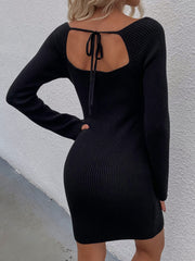 Black ribbed knit mini dress with long sleeves and a back tie detail.