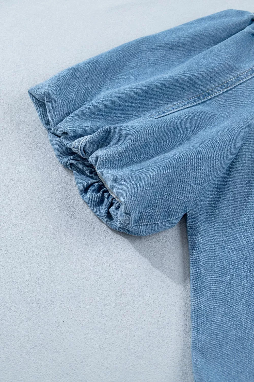 Light blue denim dress with voluminous puff sleeves and elasticated cuffs.