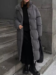 Chic dark gray padded puffer trench coat with tie-belt detail and silver zipper.