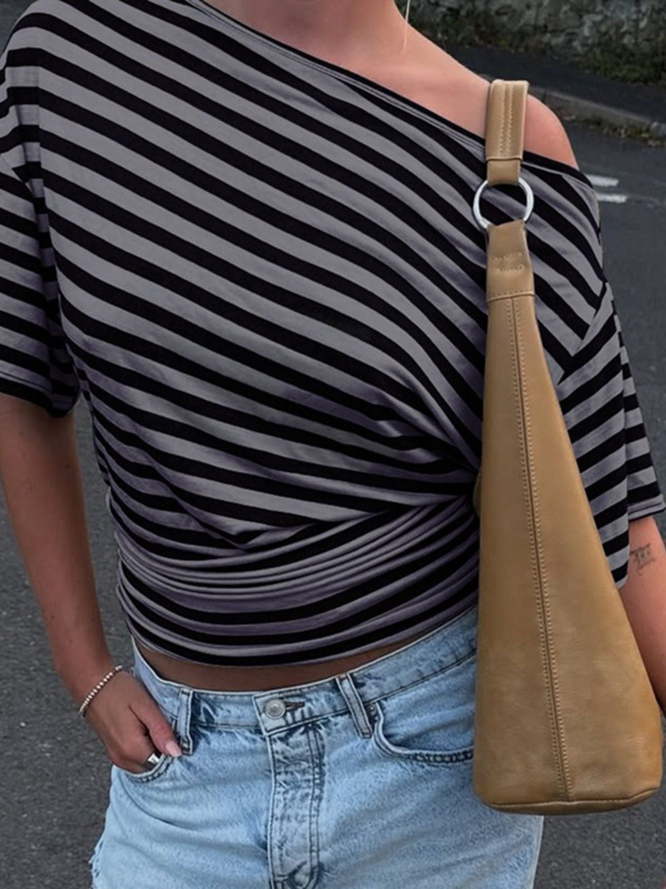 Cropped one-shoulder striped t-shirt in dark gray with a twisted hem detail.