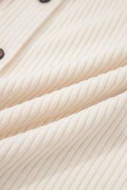 Ribbed cream button-down shirt with contrast buttons and animal print detail.